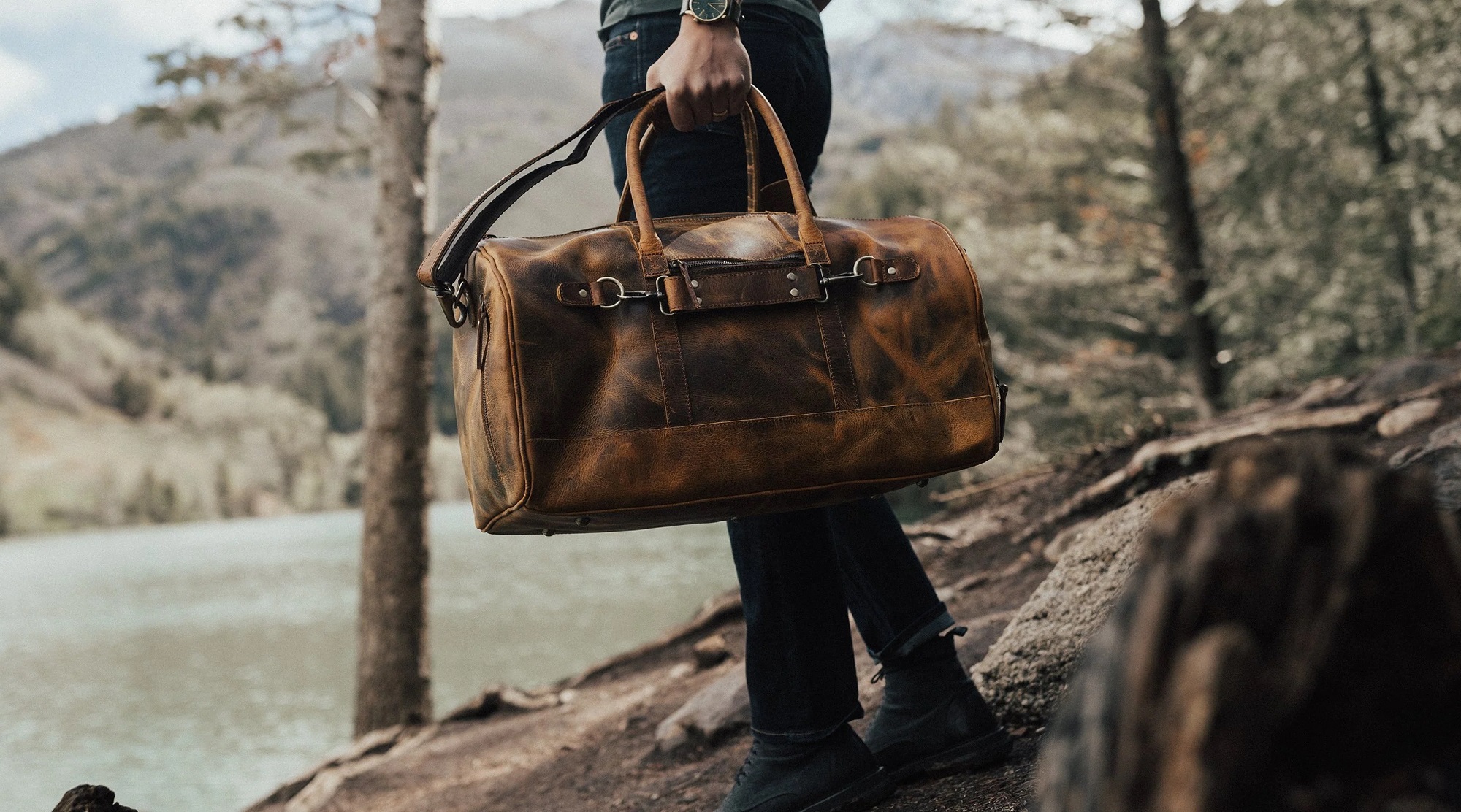 Man carrying a duffel bag in the woods